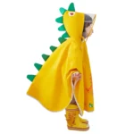 Poncho bébé léger jaune en forme de dinosaure avec écailles vertes, parfait pour jouer sous la pluie avec style et confort.