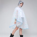 Femme souriante avec poncho pluie coloré à motifs bleus, pratique et élégant pour rester au sec lors des averses urbaines.