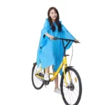 Femme en poncho pluie imperméable bleu sur vélo jaune, protection élégante et efficace contre la pluie - [Collection].