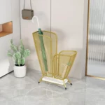 Porte-parapluie en métal doré élégant de la collection [Collection], avec parapluie vert, décoratif sur sol en marbre avec plante blanche.