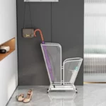 Support moderne en métal blanc pour parapluies, avec parapluie violet et bouteille d'eau, idéal pour une entrée élégante.