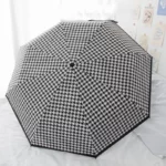 Parapluie anglais automatique, motif pied-de-poule noir et blanc, chic et fonctionnel, pour un style intemporel sous la pluie.