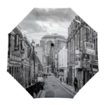 Parapluie anglais coloré, design urbain avec impression noir et blanc d'une rue animée, bâtiments et panneaux de magasin.