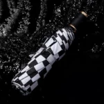 Parapluie anglais femme à motifs damier noir et blanc, élégant et raffiné, idéal pour les journées pluvieuses.