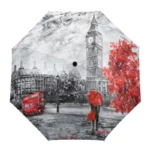 Parapluie anglais original avec illustration de Londres : Big Ben, bus rouge, arbres aux feuilles rouges, ciel nuageux.
