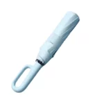 Parapluie anti retournement bleu vintage, solide et élégant, détail du manche ergonomique et du mécanisme d'ouverture ingénieux.