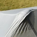 Parapluie de pêche léger et robuste, détail des coutures étanches en bord de rivière, parfait pour une protection durable.