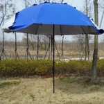 Parapluie de pêche bleu en extérieur, style parasol, idéal pour le jardin, protection contre la pluie et le soleil, arbres en arrière-plan.