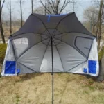 Parapluie de pêche gris-bleu, spacieux et résistant, installé en extérieur sous des arbres, parfait pour les activités de plein air.