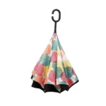 Parapluie inversé chic avec motifs de feuilles colorées rose, jaune, vert, suspendu, poignée ergonomique en C, élégant et pratique.