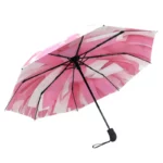 Parapluie original rose et blanc, style abstrait moderne, ouvert avec armature noire élégante, parfait pour un look coloré.