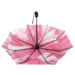Parapluie original coloré, motif rose et blanc, design frais et dynamique, structure noire robuste, idéal toute saison.