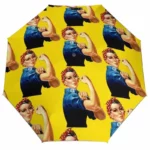 Parapluie vintage avec motifs féminins inspirants sur fond jaune, célébrant la force et l'élégance. Accessoire unique.