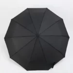 Parapluie tempête léger noir, structure octogonale robuste, coutures visibles, idéal contre la pluie, design élégant et durable.