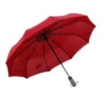 Parapluie tempête léger rouge, durable et élégant, avec structure noire, parfait pour se protéger de la pluie et du vent.