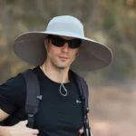 Homme avec chapeau de pluie à larges bords anti-UV E27, imperméable, idéal pour protection extérieure, de la collection [Collection].