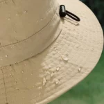 Chapeau de pluie bob femme élégant, bord de 6 mm, taille E 27. Idéal sous la pluie, style chic, avec effets de gouttes d'eau.