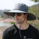 Chapeau de pluie anti-UV pour homme à large bord gris, idéal pour se protéger du soleil lors d'activités en plein air.