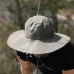Chapeau de pluie anti-UV homme à large bord, étanche avec gouttes d'eau visibles, idéal pour protéger en toutes conditions humides.