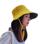 Chapeau de pluie jaune souple pour femme, large bord et attache sous le menton, parfait pour protection soleil et pluie.