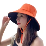 Chapeau de pluie bob souple orange avec bord noir et cordon, mode femme, protection soleil et pluie, idéal plein air.