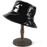 Chapeau de pluie bob noir verni imperméable en vinyle brillant, accessoire chic et pratique pour affronter les jours de pluie.