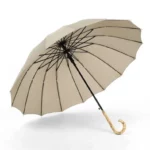Grand parapluie canne en bambou, toile beige, arceaux noirs, poignée en bois courbé, accessoire chic et pratique pour la pluie.