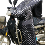 Tablier scooter noir à pois blancs, élégant et pratique, idéal pour se protéger de la pluie en toutes saisons.