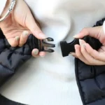 Femme attachant un tablier scooter bouffant de la collection [Collection], offrant protection contre la pluie et le vent.