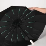 Parapluie pliant beige à baleines doubles, robuste et élégant, parfait pour vous protéger avec style par temps pluvieux.