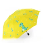 Parapluie enfant automatique motif dinosaure, jaune avec dinosaures bleus et étoiles blanches, idéal pour jours de pluie ludiques.