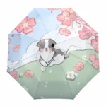 Parapluie enfant multicolore avec illustration d'un chihuahua mignon sur pelouse verte, fleurs roses et ciel bleu avec nuages.