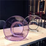 Chapeaux de pluie transparents, violet et incolore, élégants et pratiques sur une table en bois. Parfaits pour rester stylé sous la pluie.