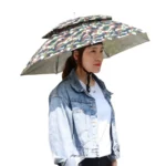 Chapeau parapluie anti-UV imperméable avec trappe d’aération, design camouflage, idéal soleil et pluie, porté par une femme stylée.