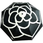 Parapluie de luxe noir et blanc avec motif floral élégant, design moderne, parfait pour un style raffiné en toutes saisons.