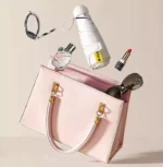 Parapluie femme cœur pliant, élégant et compact, présenté avec des accessoires de mode féminins dans un sac à main rose.