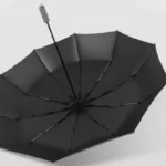 Parapluie tempête grand format noir ouvert, robuste et élégant, idéal pour affronter les intempéries avec style et résistance.