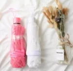 Parapluie transparent en dentelle, élégant et romantique, accompagné d'un vase avec fleurs séchées, design unique et raffiné.