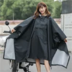 Poncho femme noir avec poche et capuche, élégant et fonctionnel, idéal pour moto et pluie, parfait en extérieur.
