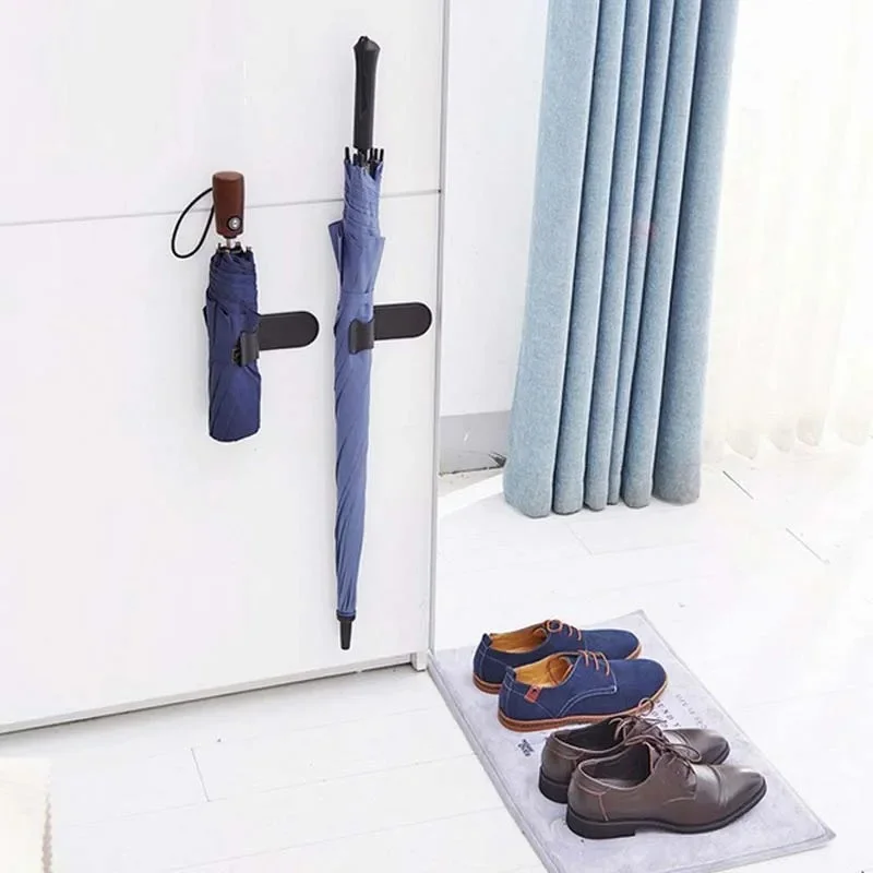 Porte-parapluie de voiture en PVC noir avec un parapluie bleu accroché, un parapluie plié et des chaussures sur un tapis au sol.