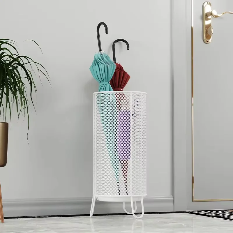 Porte-parapluie en métal doré cylindrique, design moderne, avec parapluies turquoise et bordeaux, sur fond neutre élégant.