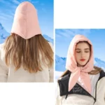 Capuche molletonnée rose avec nœud, idéale contre froid et pluie, portée par une femme devant un paysage montagneux hivernal.