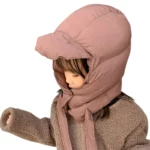 Enfant avec doudoune anti-froid et capuche rose avec visière, parfait pour affronter la pluie et le froid avec style et confort.