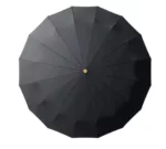 Parapluie homme chic noir octogonal avec segments harmonieux et bouton central doré, idéal pour un style élégant sous la pluie.