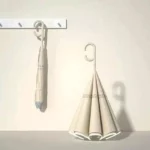 Parapluie inversé pastel crème moderne accroché, design minimaliste pour protection pluie, accessoire tendance et fonctionnel.