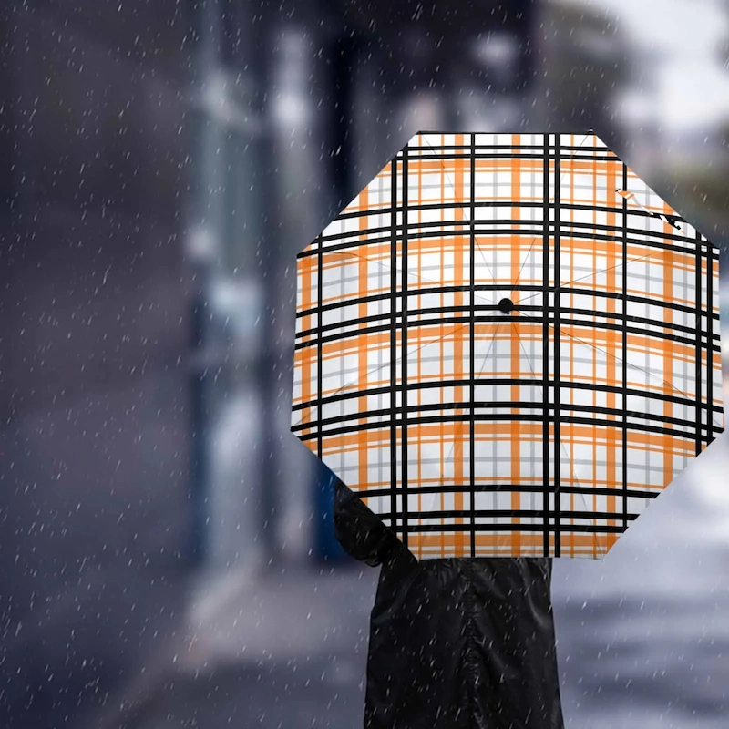 Parapluie automatique à carreaux orange noir, design élégant, accessoire moderne pour se protéger de la pluie en ville.