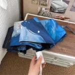 Parapluie bleu automatique avec motifs de chat, design élégant et pratique dans un intérieur chaleureux et stylé.