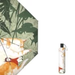 Parapluie noir manuel avec dessins artistiques dessous : chat orangé allongé dans un jardin verdoyant, design mignon et unique.