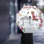 Parapluie chien automatique rose et blanc, stylé avec motifs floraux, parfait pour rester élégant sous la pluie.