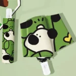 Parapluie chien automatique vert avec motif ludique et poignée blanche, parfait pour ajouter une touche amusante sous la pluie.